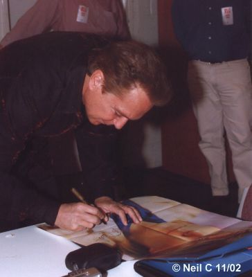 David signs the poster from Romance LP.